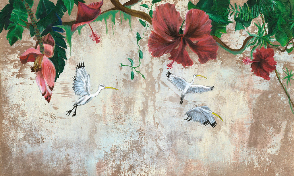 Papier peint panoramique Vol d'ébysiens d'Amélie Noel représentant des fleurs d'hibiscus, des feuillages tropicaux et trois oiseaux blancs en plein vol.
